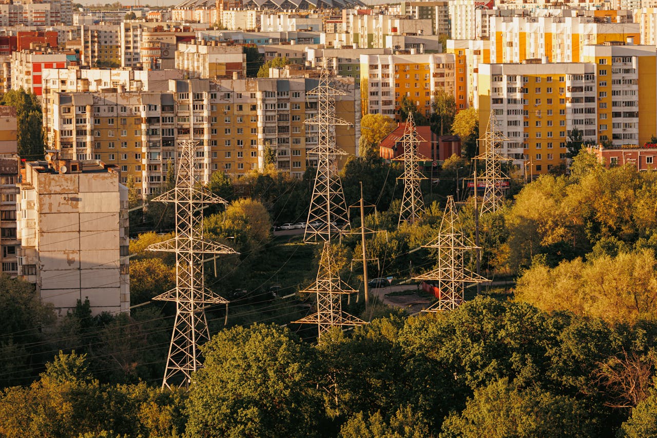 Aerial view of urban cityscape with high-voltage power lines and apartment buildings in autumn.